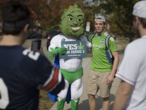 Buddie, the mascot for the pro-marijuana legalization group ResponsibleOhio, poses for photos with passing college students at Miami University, Oct. 23, 2015, in Oxford, Ohio. (Photo: John Minchillo, AP)