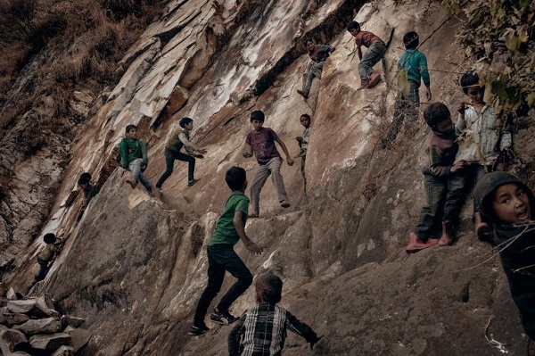 Village children playing on a steep cliff at the outskirts of the village. Families have many children, some are left with older siblings during the day. PHOTOGRAPH BY ANDREA DE FRANCISCIS